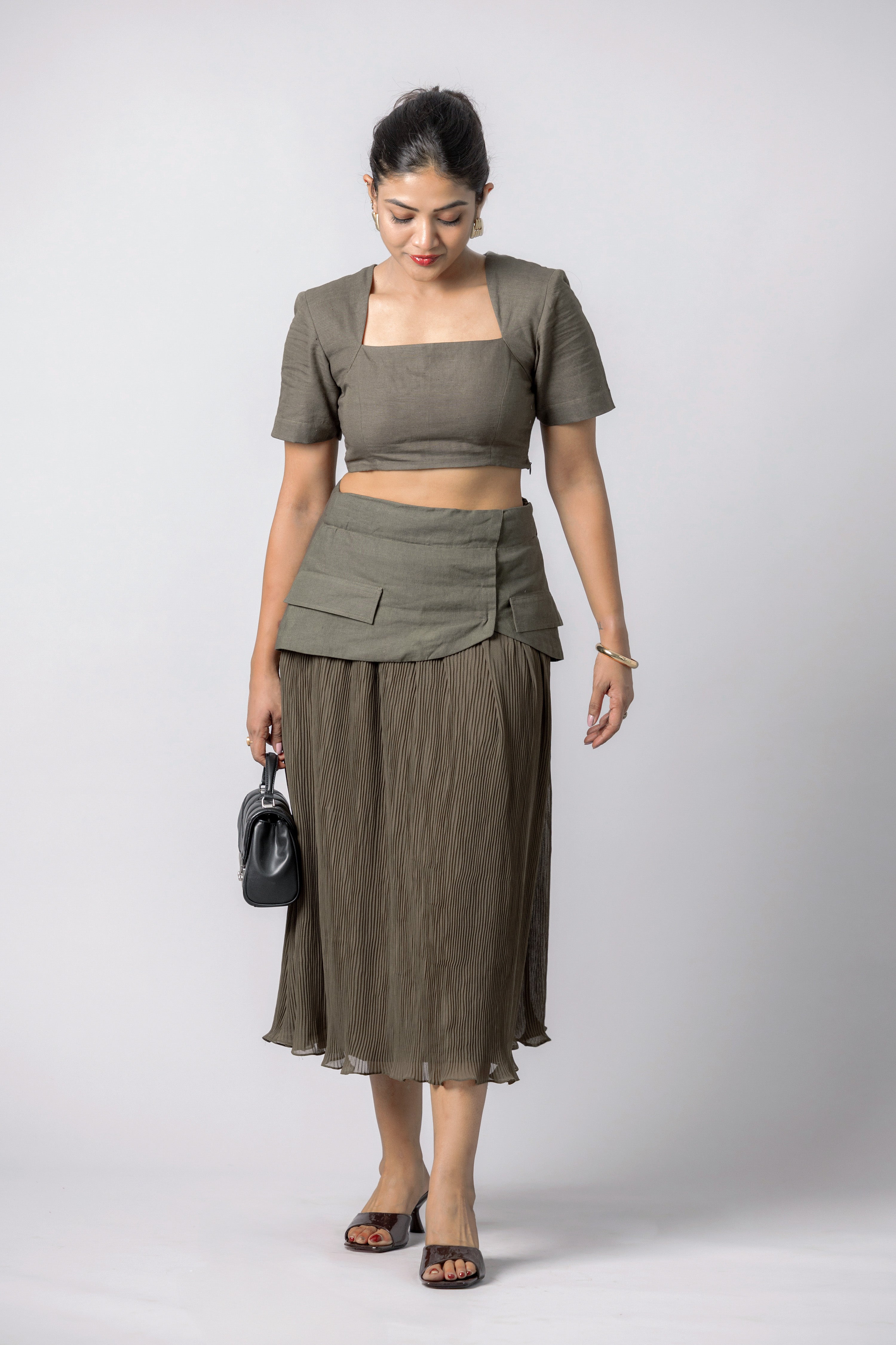 Woman wearing olive crop top and pleated midi skirt co-ord set