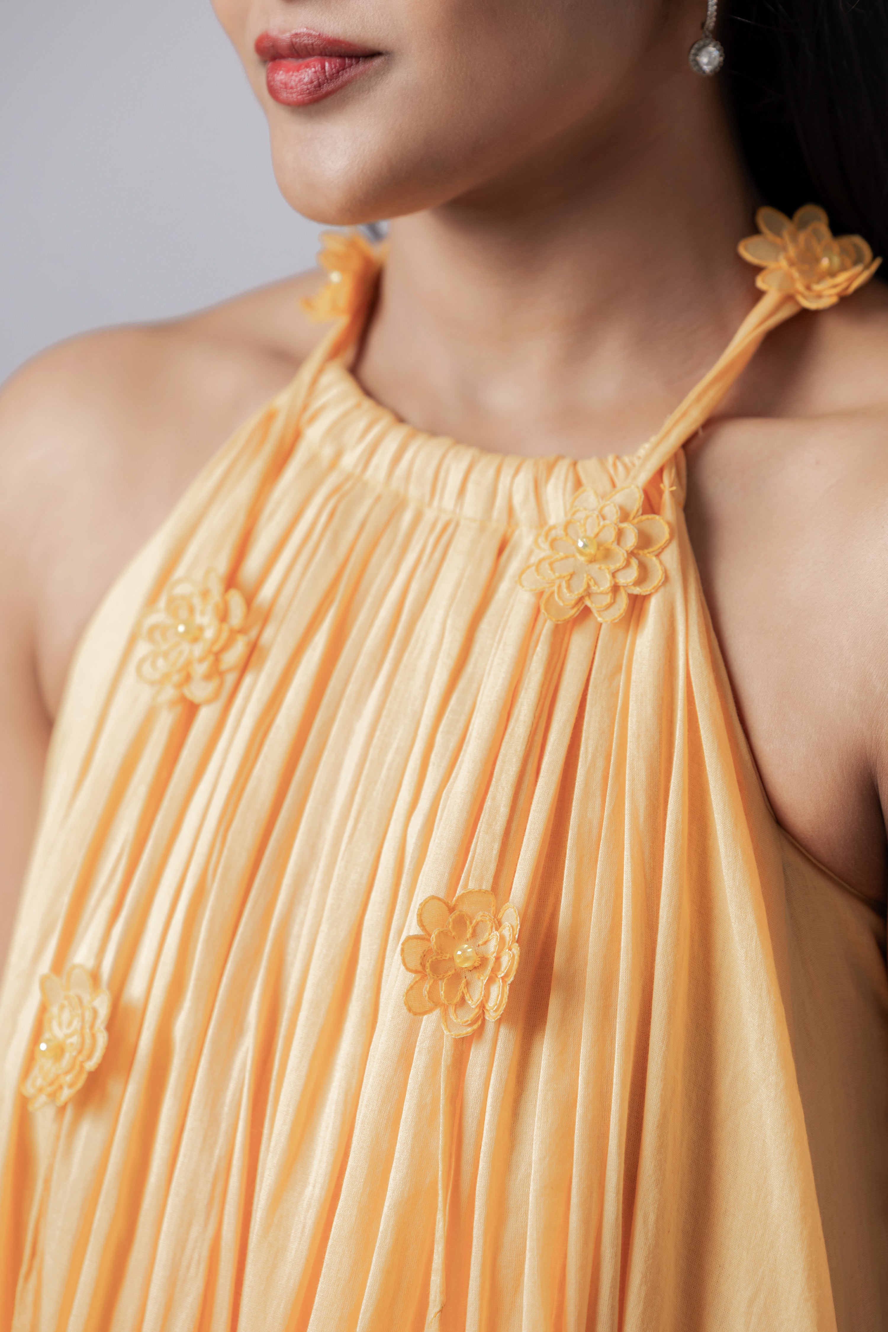 Close-up of 3D floral appliqué on peach halter dress