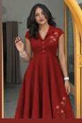 Woman wearing a red dress with floral embroidery indoors